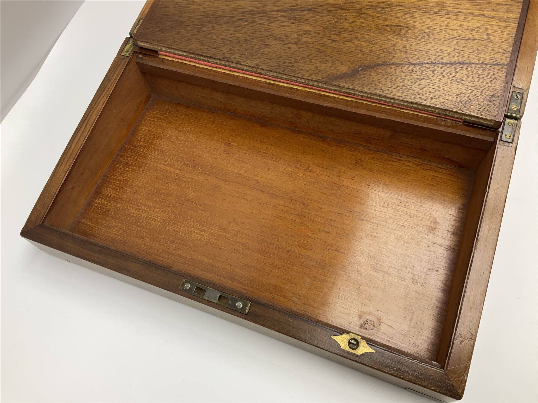 19th century burr yew wood tea caddy, of sarcophagus form, with strung details and brass mounts, the interior split into three compartments, upon four brass bun feet, together with an oak and brass bound writing slope, with red leather interior with gilt detailing, largest H16cm, W40cm