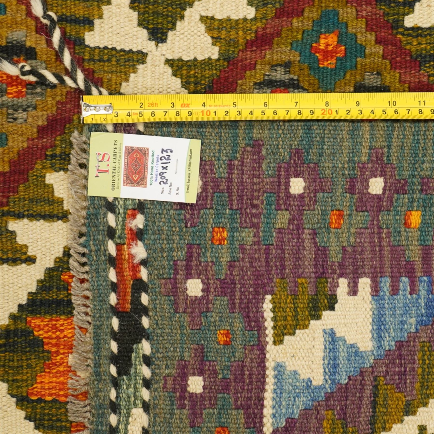 Afghan Maimana flatweave kilim, central field features large bold nested diamond motifs and stylized geometric lozenge patterns on olive purple, blue, and green tone ground, dark green border stripe, with fringe ends