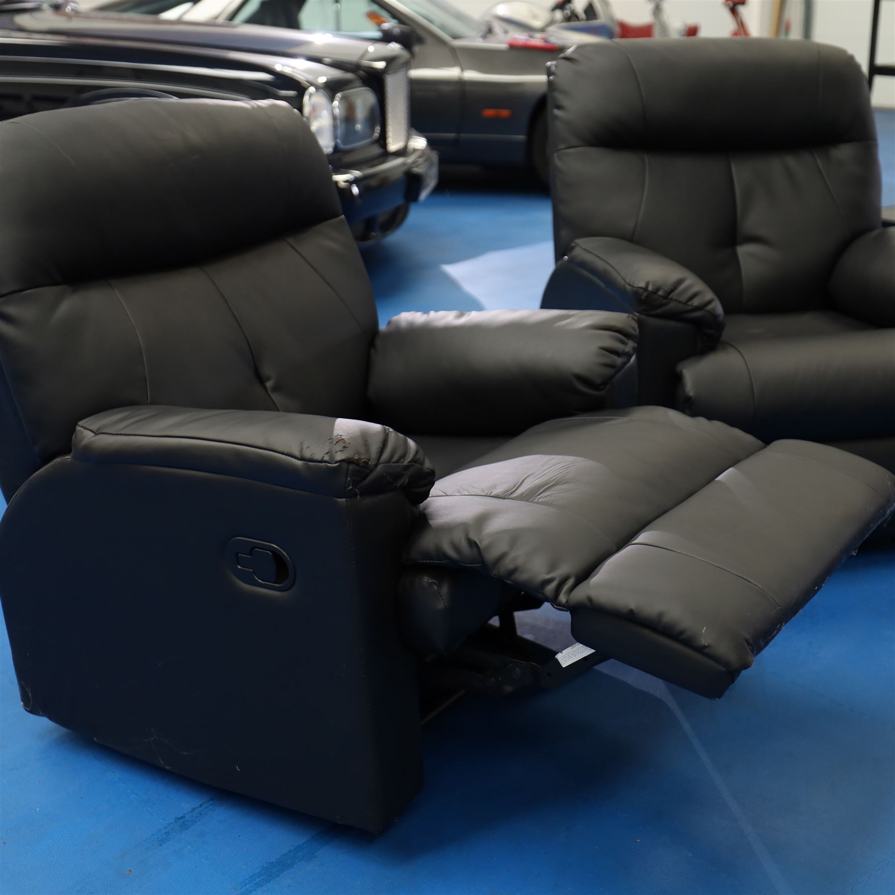 Two reclining armchairs upholstered in black faux leather