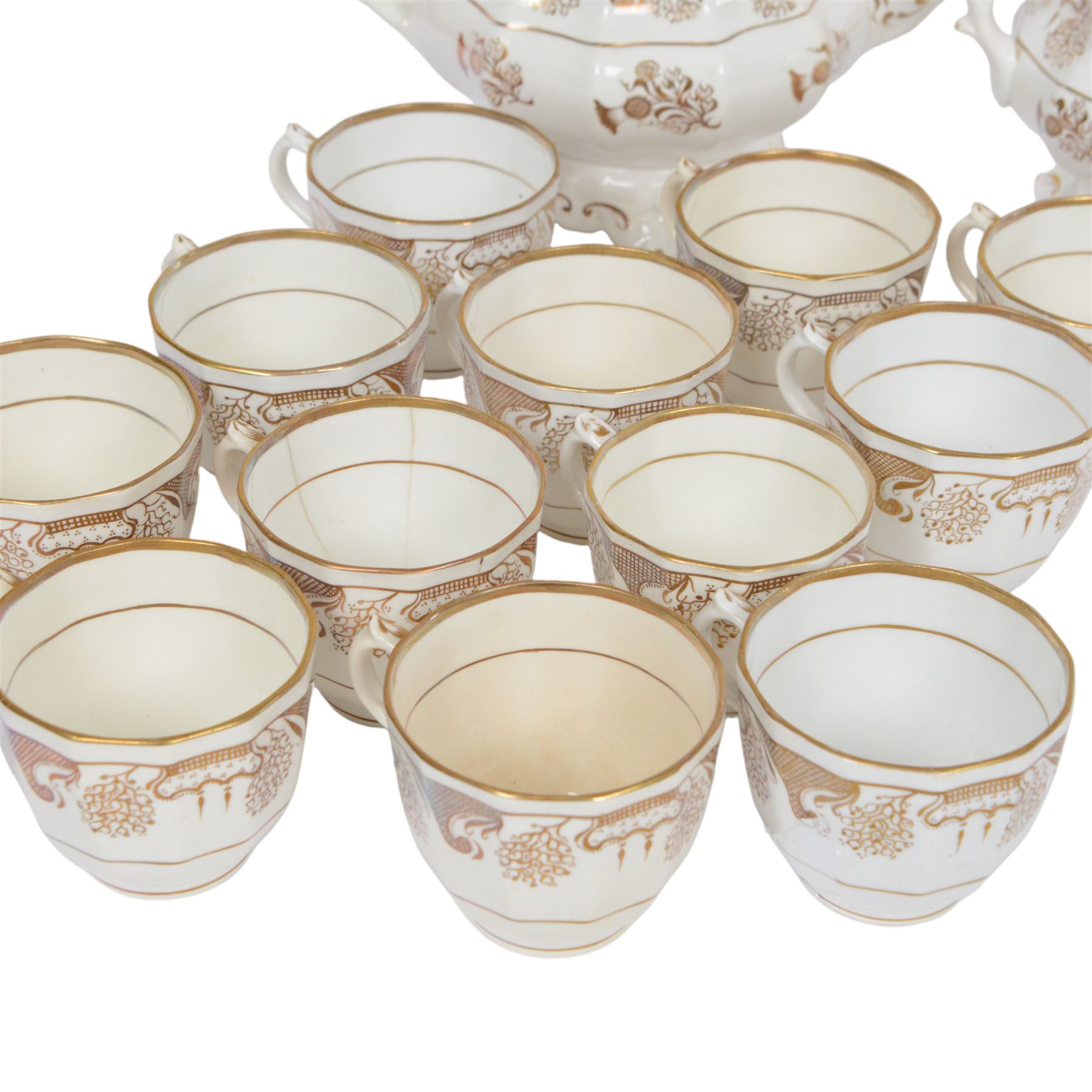 Late 19th century tea service, decorated in gilt with bands of seaweed type tendrils, thistles and cross hatch reserves upon a white glazed ground, comprising tea pot, twin handle lidded sucrier, milk jug, slop bowl, three serving plates, twelve cups and saucers and eleven side plates