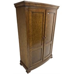Regency design walnut bow-front double wardrobe, enclosed by panelled doors