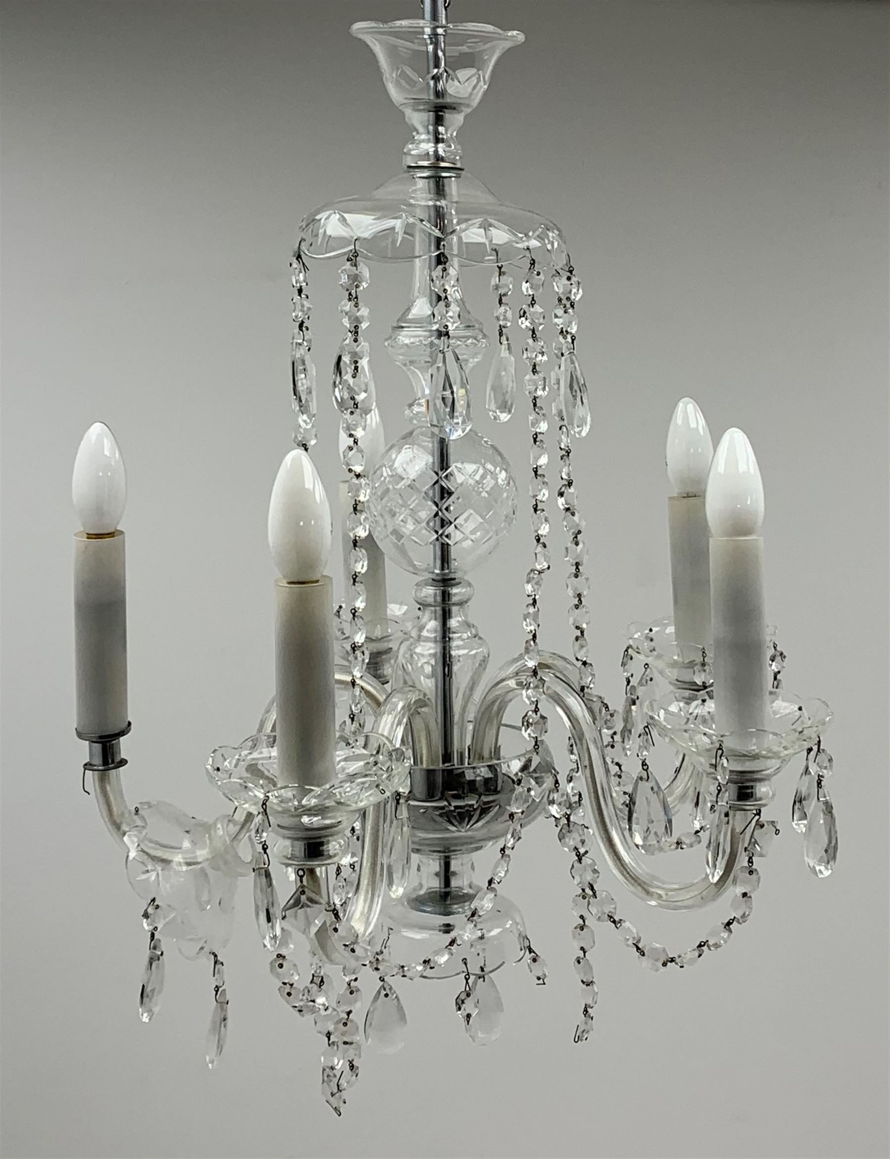 A glass chandelier, with five curved branches with drip pans and droppers, approximately H69cm. 