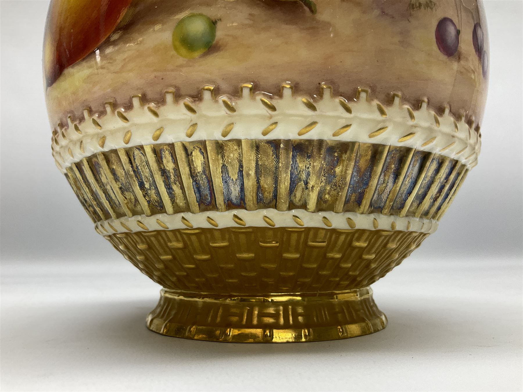 Mid 20th century Royal Worcester potpourri vase and cover decorated by Alan Telford, of ovoid form with inner cover and pierced gilt outer cover with bud finial, upon short gilt circular foot, the body part moulded with basket weave bands in gilt and bronze, and hand painted with a still life of fruit upon a mossy ground, signed Telford, with black printed mark beneath and painted shape number 1286, H25.5cm