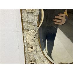 Pair 19th century French Dieppe bone and ivory wall mirrors, the oval bevelled mirror plates within rectangular frames with shaped tops, profusely decorated with ivory leaves, further detailed with carved bone armorial type crest inscribed 'SGOTORVM', putti, fish and mask heads, H81cm W48cm