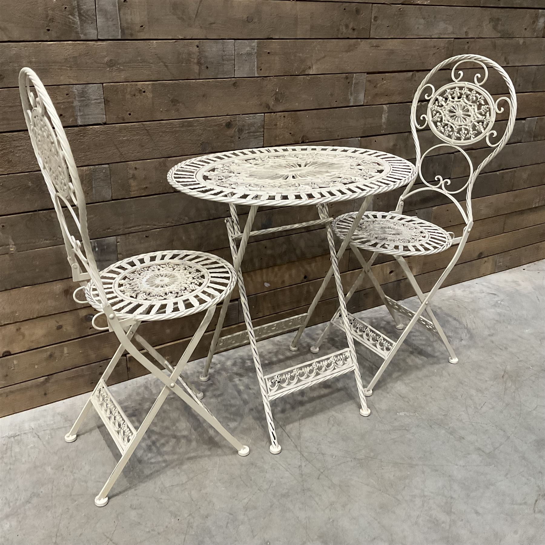 Cast metal bistro set including ornate oval garden table and two matching chairs