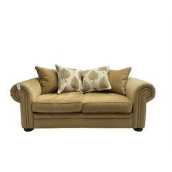 Contemporary two seat sofa bed, upholstered in textured champagne fabric, with contrasting scatter cushions