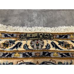 Large fine Persian Kashan carpet, ivory ground and decorated with interlacing foliage and stylised flowers heads, repeating multi-band border with scrolling decoration and plant motifs, with signature panel