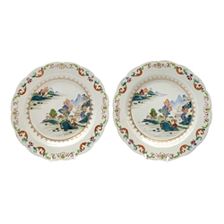 Pair of Chinese Export Famille Rose plates, Qianlong period, enamelled in polychrome with flowers, rockwork and pagoda to the foreground shore, an island beyond, within a floral scroll border, D23cm   