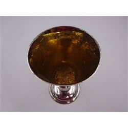 Modern limited edition silver goblet, a replica of the original silver chalice of Lincoln Cathedral, with hand planished decoration, and engraved band of laurel leaves to bowl, with gilt interior, upon waisted stem and circular stepped foot, no. 144/200, hallmarked John Cussell, London 1977, H15cm