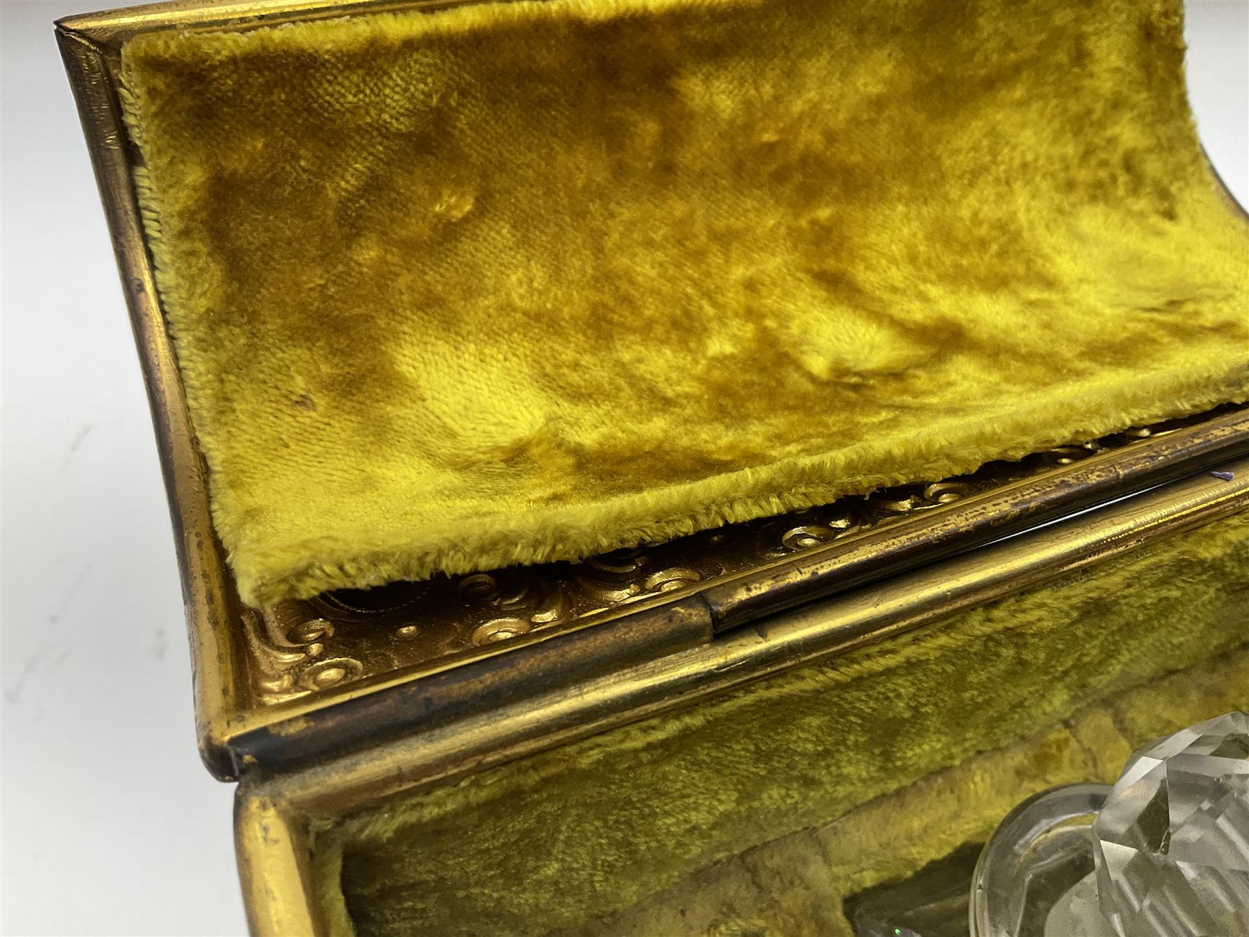 19th century brass repoussé perfume box, the ornately decorated casket with hinged domed cover lifting to reveal gold velvet lined interior containing three glass scent bottles, H14cm W15cm D7cm