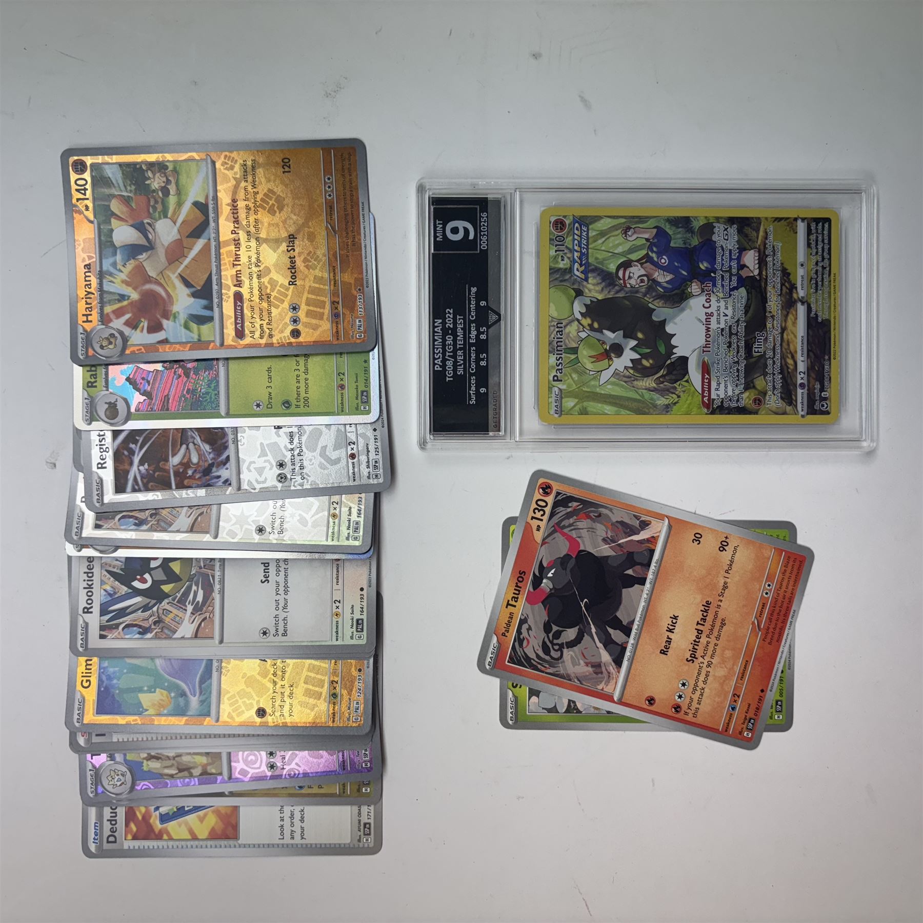 Collection of modern Pokemon TCG trading cards from the Scarlet & Violet and Sword & Shield eras, contained within in two folders, opened packets and loose, together with a graded Sword & Shield Silver Tempest Passiman TG08, GET Graded 9 Mint, two oversized cards, energy cards, vintage booklets and boxes, empty tins, 1998 Electronic Pokédex and other accessories