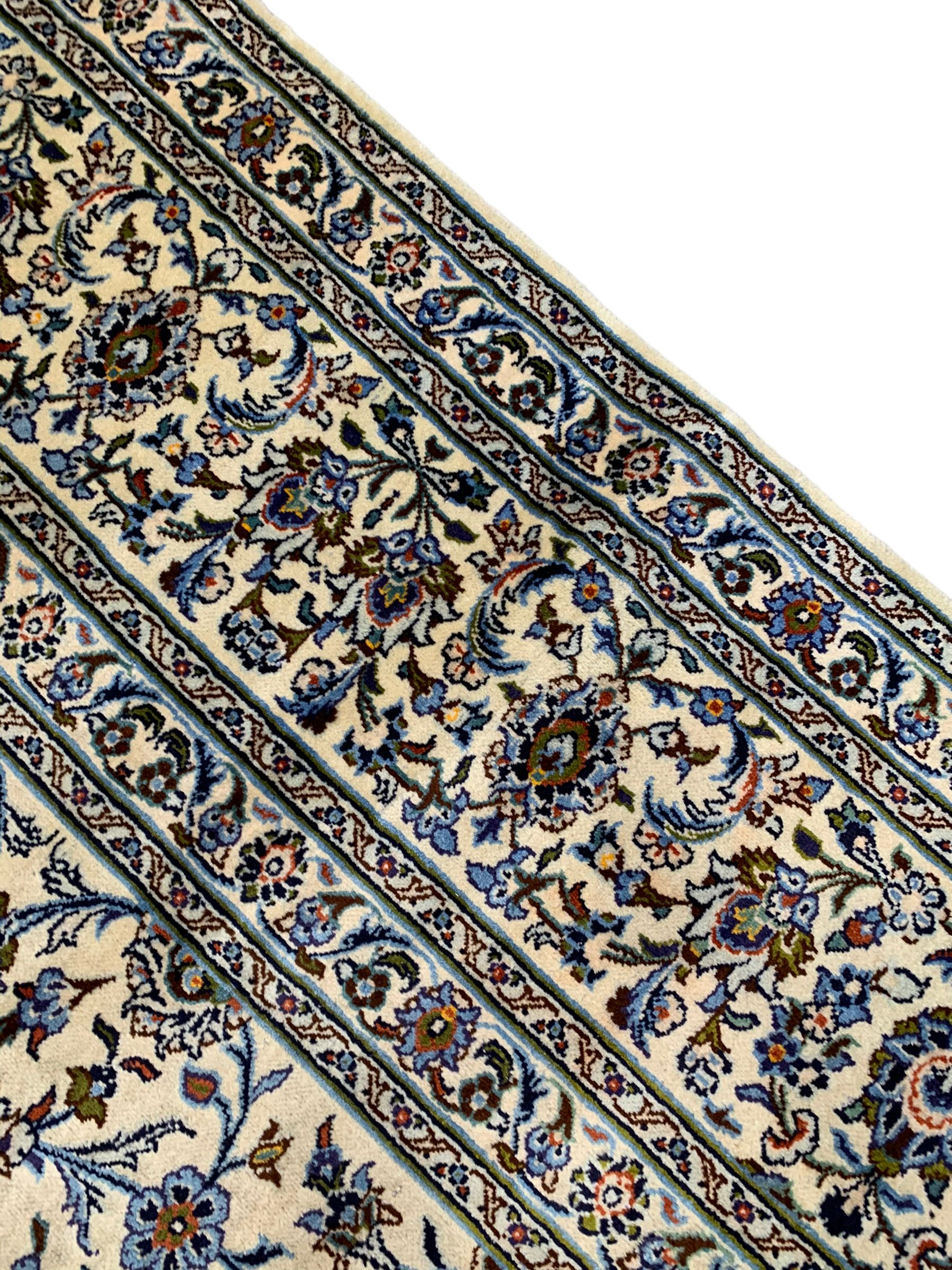 Persian Kashan ivory ground carpet, the field decorated with interlacing leafy branches and stylised plant motifs, repeating border with multiple guards