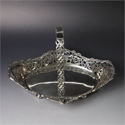 Early 20th century swing handled basket, of oval form with pierced sides and floral C scroll rim, upon four bun feet, hallmarked William Hutton & Sons Ltd, Sheffield 1915, widest point W29cm