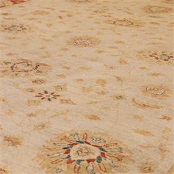 Indo-Persian Ziegler style Farahan design hand-knotted wool carpet, ivory field with open composition with dispersed palmettes, floral sprays and scrolling vinery with central subtle medallion enclosed within deep madder red border of complementary stylized foliate motifs