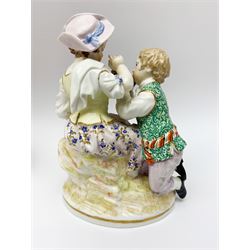 Two late 18th/early 19th century Berlin porcelain figure groups, the first example modelled as a young boy offering a hat containing apples to a young girl seated upon a stump rising from a naturalistically modelled oval base, the second modelled as a young girl playing an instrument for a young boy seated by her side, upon naturalistically modelled oval base, each with blue underglaze sceptre mark beneath, tallest H16cm