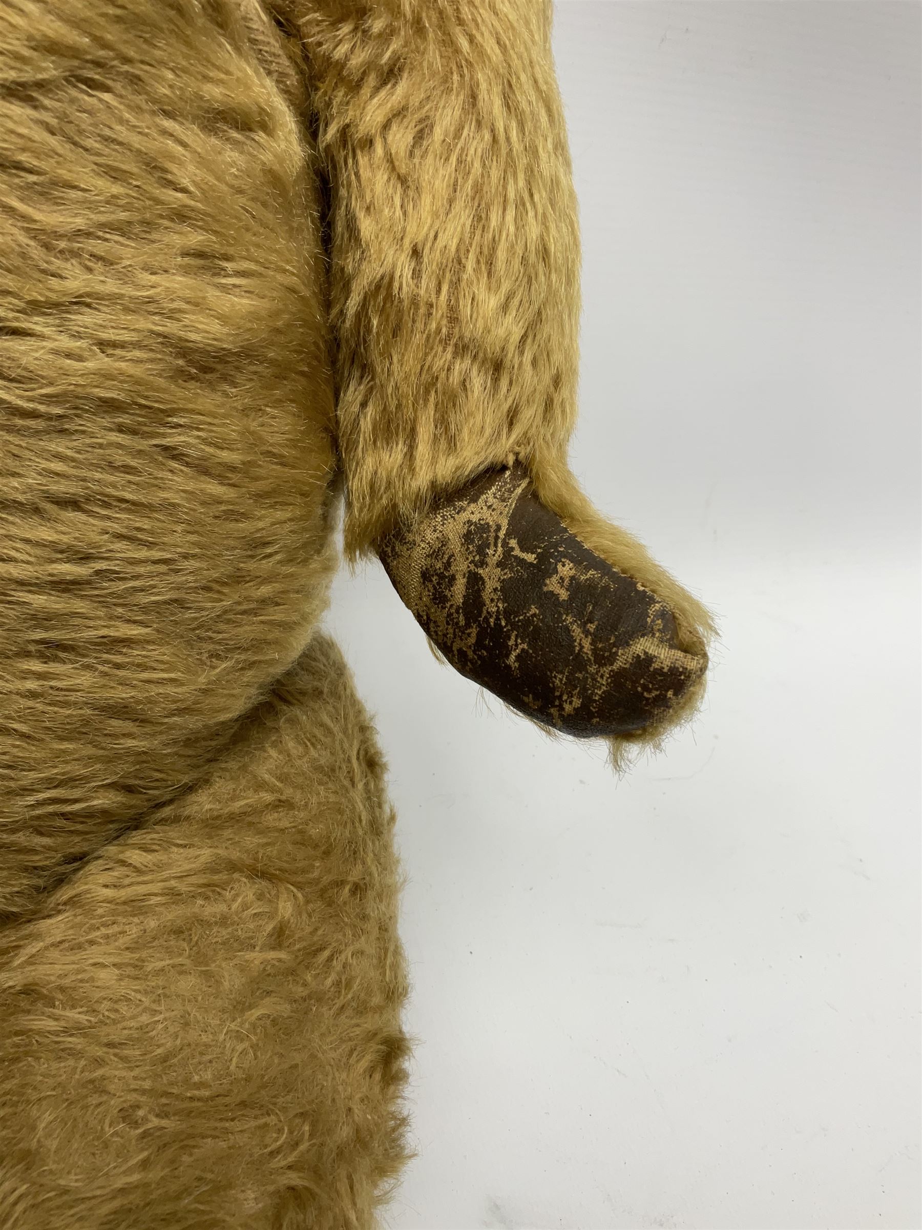 Mid-20th century plush covered teddy bear the revolving head with applied eyes, vertically stitched nose and jointed limbs with rexine pads H58cm; together with a leather backpack (2)