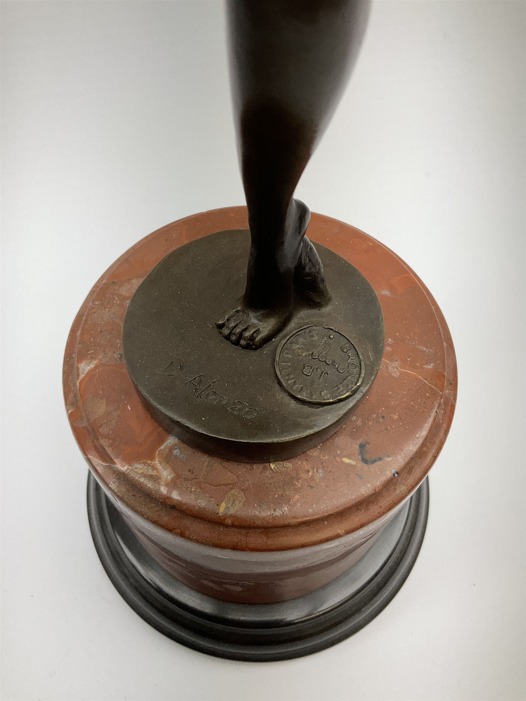 An Art Deco style bronze after D Alonzo, modelled as a dancer, with impressed mark and foundry mark, raised upon a cylindrical marble base, overall H47.5cm. 