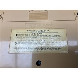 Three late 70s/early 80s handheld electronic games; Bandai Electronics Arcade ‘Gunfighter’ (1980), Grandstand ‘Invader From Space’ (1980), Palitoy ‘Merlin The Electronic Game Machine’ (1979) with game sheet and instruction booklet, all with original boxes (3) 