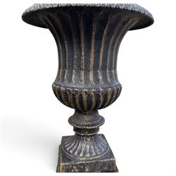 Pair of Neoclassical design black and gilt painted cast iron garden urns of campana form, with egg-and-dart rims and fluted bodies, on knopped stems, fluted socles and stepped square plinth bases