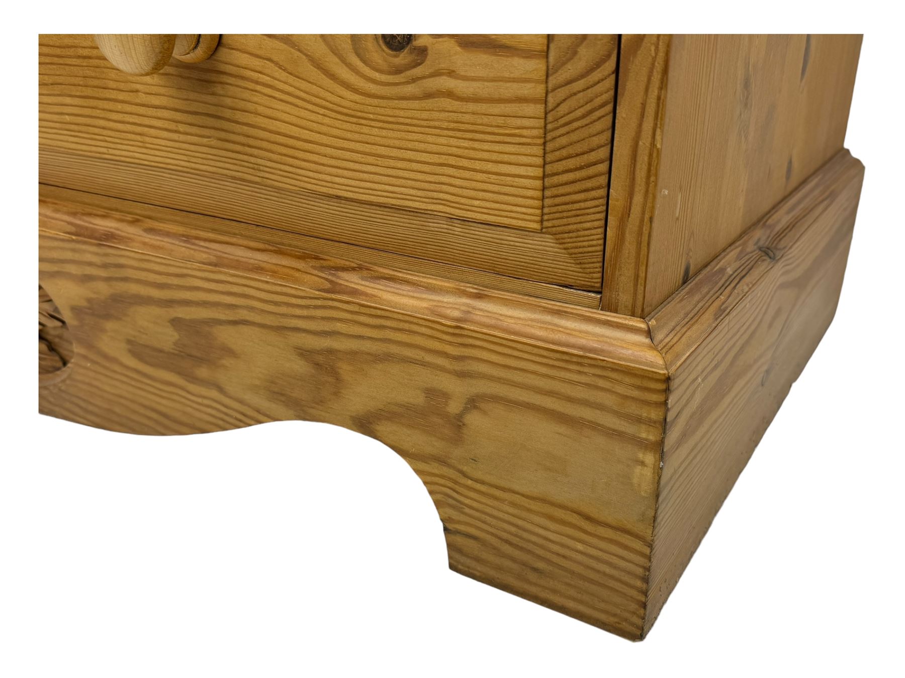 Pine chest of drawers topped with carved pediment with acorn and oak leaf motif, fitted with two short over three long drawers, standing on shaped apron base (W92, D46, H97cm); pine bedside cabinet, single drawer above paneled cupboard door enclosing open storage, shaped plinth base (W43, L32, H67cm)