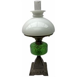 Late Victorian oil lamp, the cast metal base decorated with foliate tendrils, supporting a green glass reservoir, and opaque glass shade and clear class chimney, H60cm. 