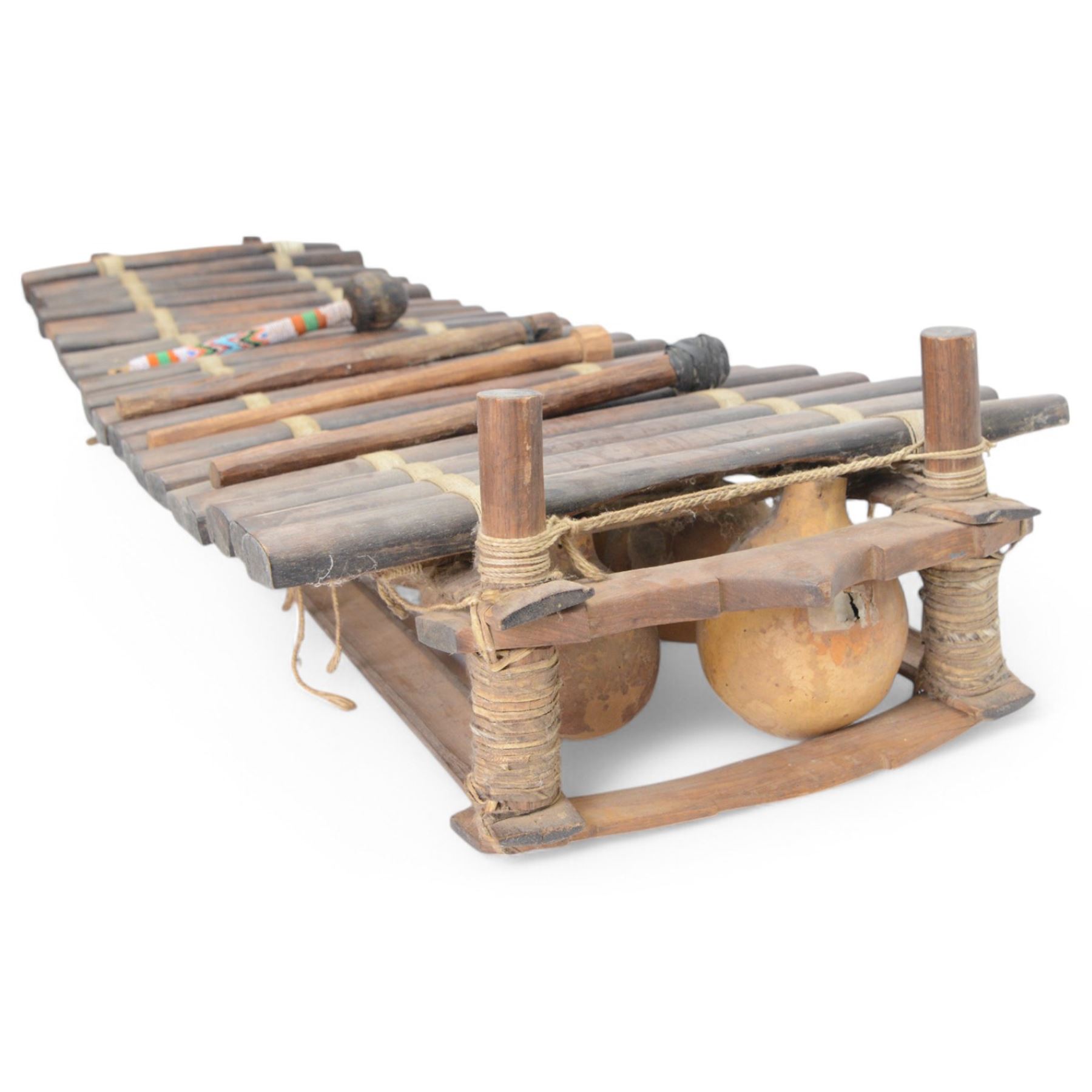 West African gourd-resonated balafon, with twenty hardwood tone bars and four beaters, L112cm