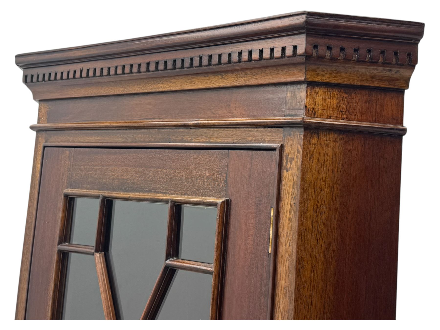 Late 20th century mahogany corner cabinet, dentil moulded cornice above a glazed door with astragal glazing enclosing two shelves, lower cupboard with fielded panel door and turned shell motif, on plinth base