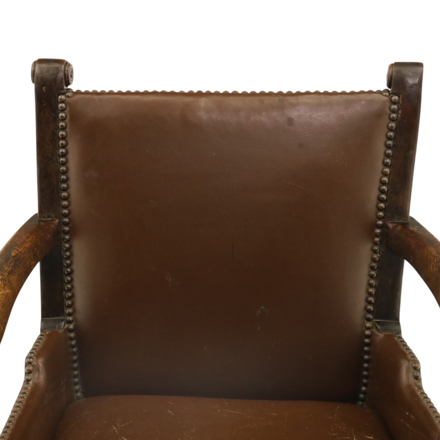 DD CL - Early 20th century oak open armchair, rectangular back with scrolled uprights, brown upholstered back and seat with brass stud edging, shaped open arms on turned supports, square legs united by stretchers