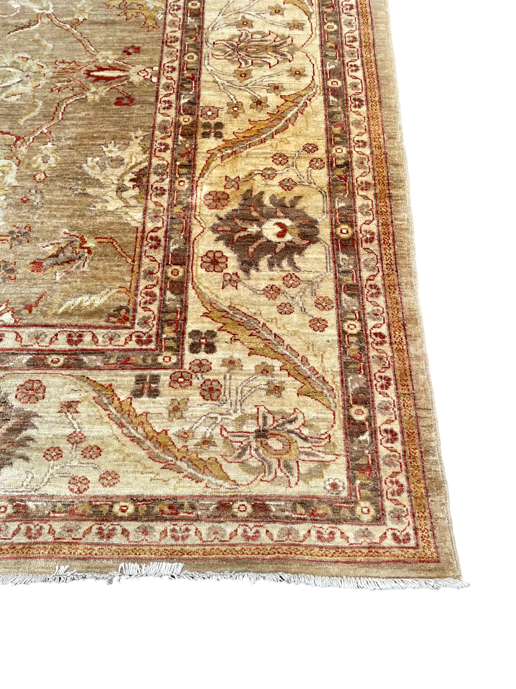 Pakistani ivory ground carpet, the field decorated with leaf branches, lotus flowers and roses, wide guarded border long leaves and stylised plant motifs