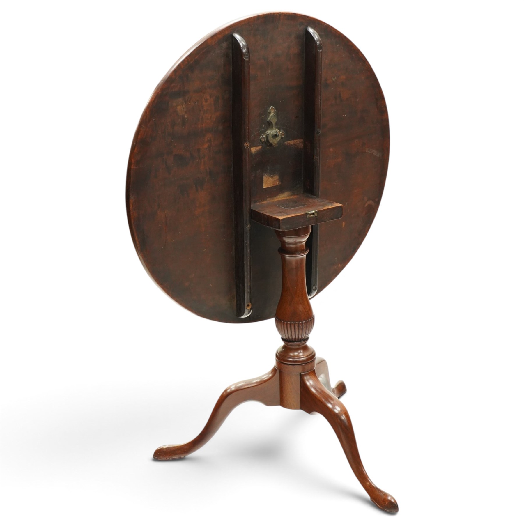 George III mahogany tilt-top tripod table, the circular figured top raised on a turned and tapering column with half-reeded lower section, over three splayed cabriole legs terminating in pad feet

Notes: several tables made by York cabinet maker John Walker for Harewood House share the same half reeded column, after the original drawing by Thomas Chippendale (c.f. The Life and Works of Thomas Chippendale, Christopher Gilbert, 1978, p.264)