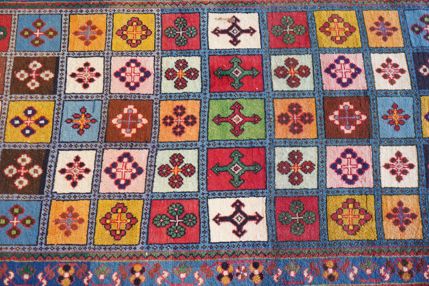 Persian Gabbeh indigo ground runner rug of garden design, the multi-coloured field decorated with five columns of panels in contrasting colours with stylised plant motifs, the guard band with trailing foliage