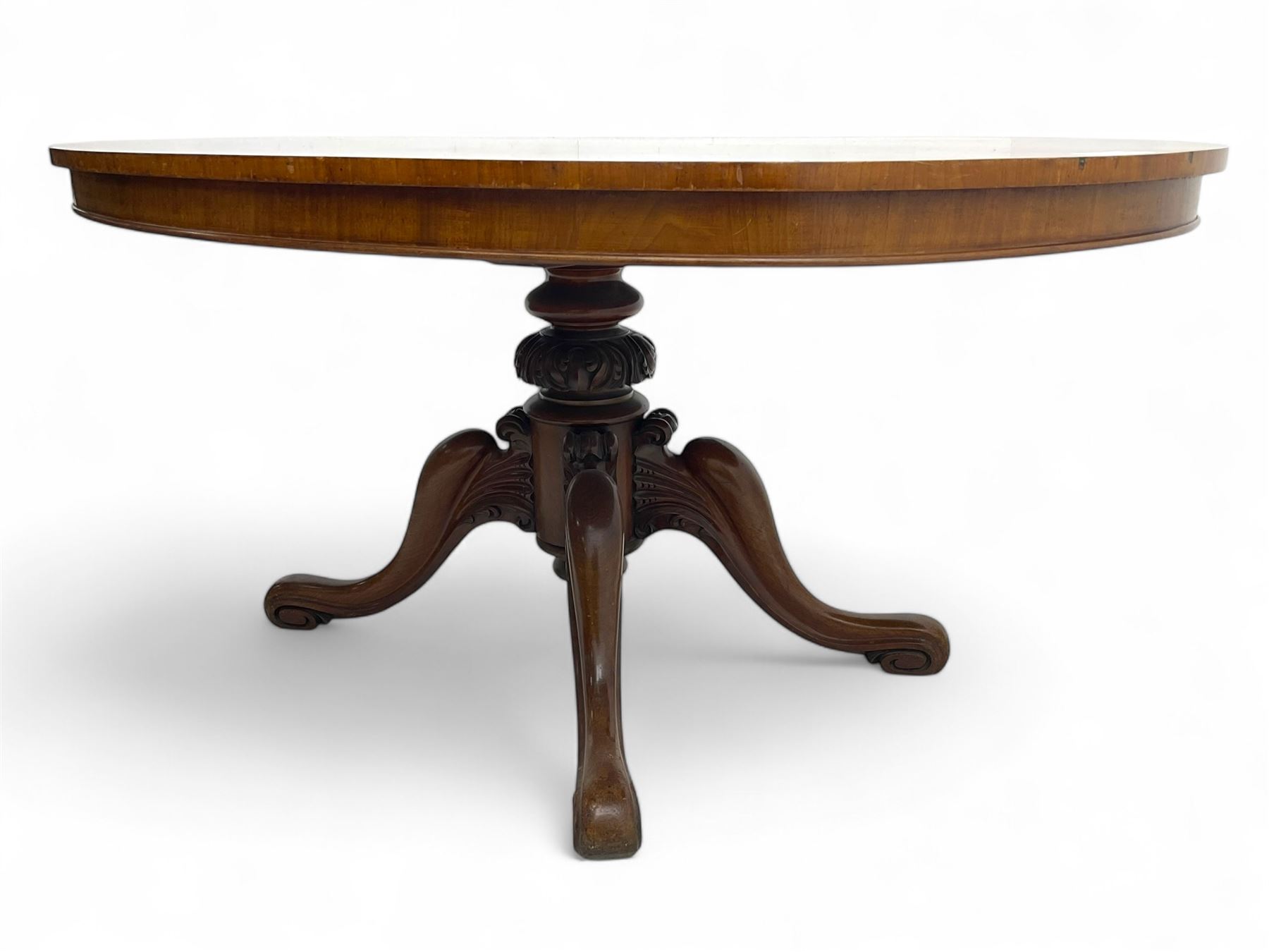 Victorian mahogany breakfast loo table, oval tilt-top on turned pedestal, quatrefoil out-splayed carved supports, scroll carved terminals with brass castors