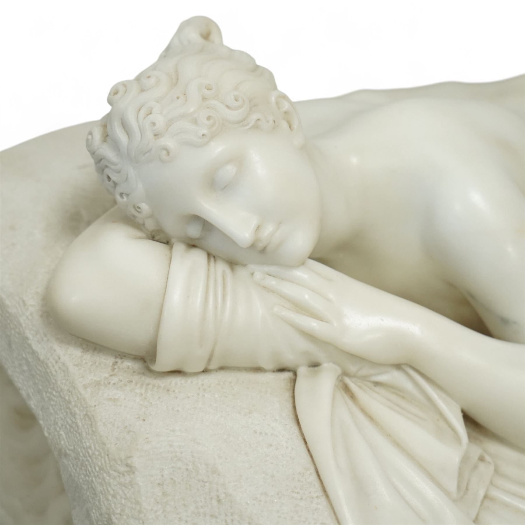 After Antonio Canova (Italian 1757-1822): 'Sleeping Venus', an Italian carved white marble figure of a reclining nude, the serene figure depicted lying on her side, her head resting on a cushion and one knee gently raised, a loosely draped sheet partially covering her lower body, on a rectangular base with rough-hewn surround, raised on a marble plinth over a sarcophagus style pedestal, circa 1900

Provenance: Kirkham Hall

Notes: A late-19th-century homage to Canova’s neoclassical models, reflecting the Grand Tour taste for idealised classical beauty and the refined finish characteristic of Italian workshop marbles of the period