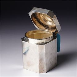 Silver square tea caddy with hinged lid and canted corners H9cm Birmingham 1912 Maker Synyer & Beddoes and a silver cream jug with crimped rim and scroll handle engraved with a crest  London 1901 Maker William Hutton & Sons