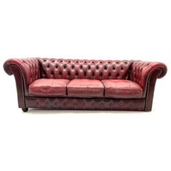 Three seat chesterfield sofa upholstered in deep buttoned ox blood studded leather, scrolling arms
