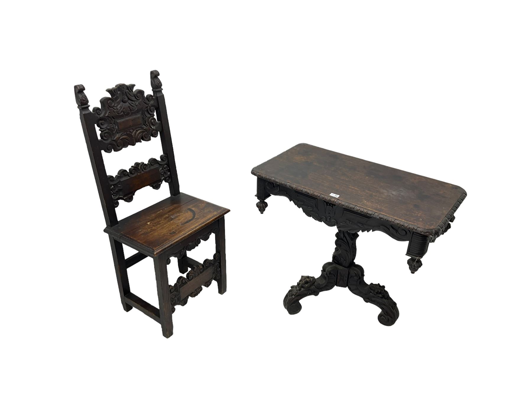 Late 19th century Gothic revival carved oak pedestal table, rectangular top with carved edges, apron carved with trailing foliate and scrolled decoration, heavily detailed column with scrolling decoration and floral carvings, the tripod base with cabriole supports carved with flowerheads (93cm x 53cm x 75cm; Late 19th century carved oak hall chair, panelled back rails with extending scroll decoration (51cm x 40cm x 116cm)