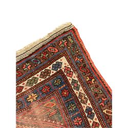 Kurdish crimson ground rug, the field decorated with four lozenge medallions, triple band border decorated with stylised flower heads