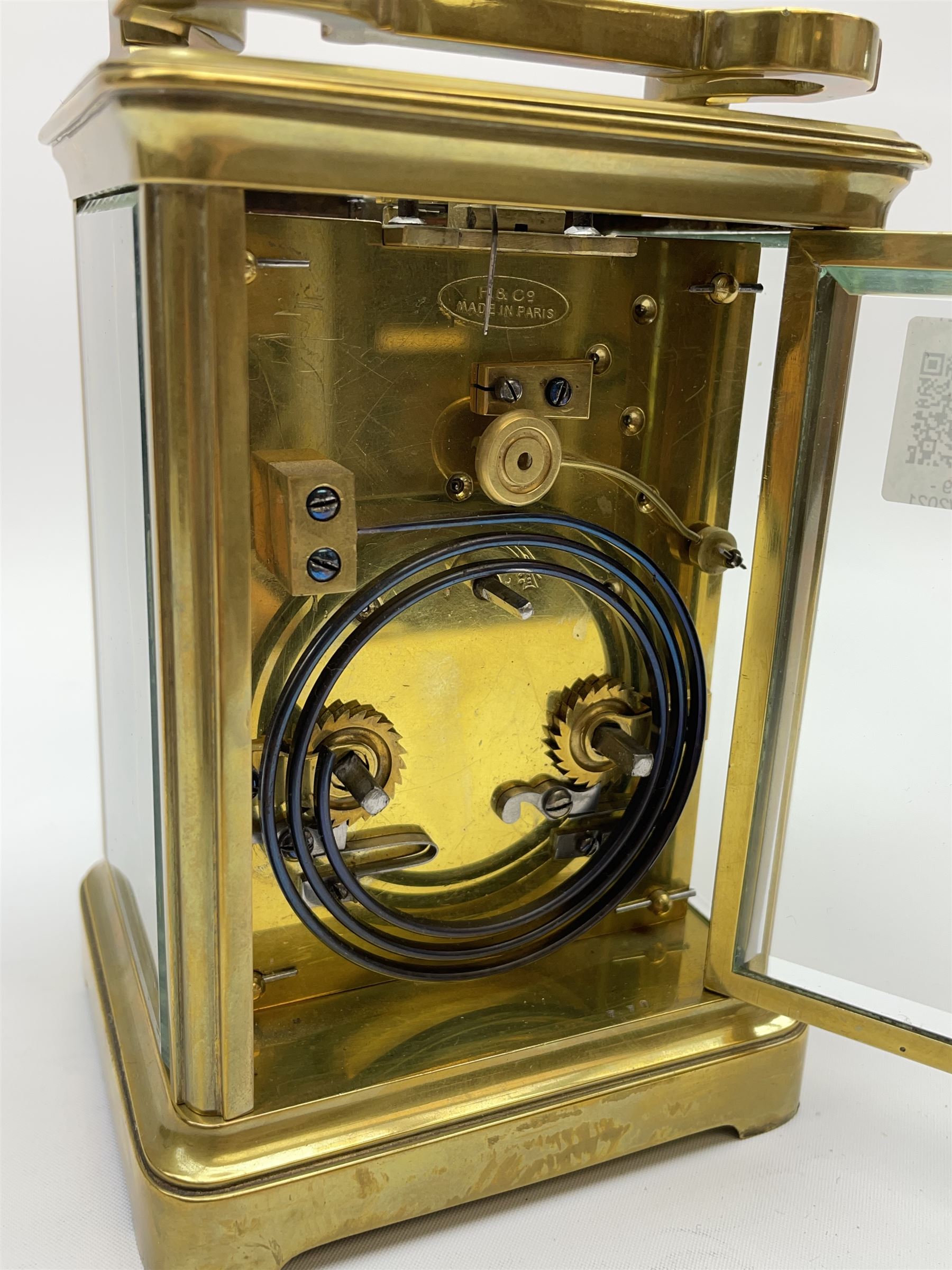 Early to mid 20th century French brass and bevelled glass cased carriage clock, the shaped loop handle over oval glass panel, white enamel Roman dial, twin train driven eight day movement striking on coil, with button push repeater, the movement back plate stamped for 'R & Co.'