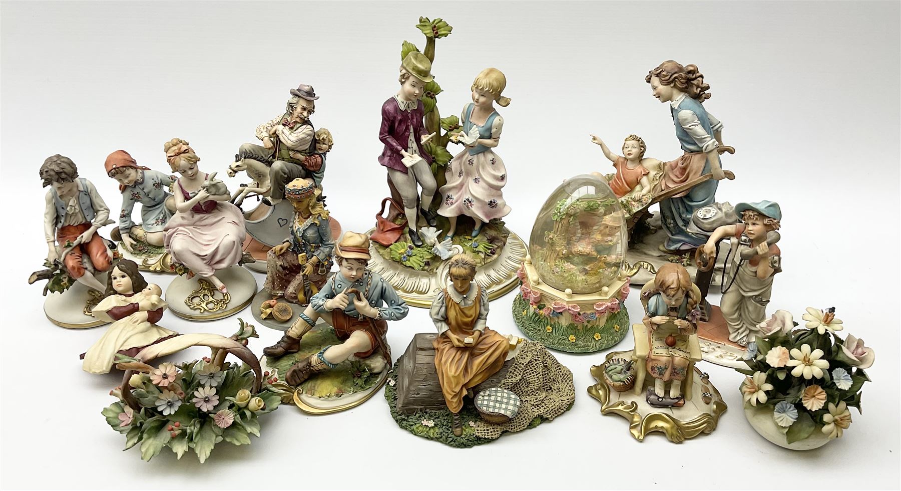 Collection of Capodimonte and Naples figures, including boy with telephone, boy and girl by a tree, man on rocking horse etc.  