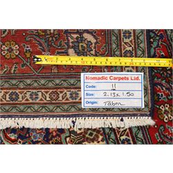 North West Persian Tabriz hand-knotted rug, ivory field with a central lozenge medallion in deep indigo and madder red, enclosing a inner reserve with stylized floral motifs, spandrels with angular floral sprays, main border of repeating floral vinery and palmettes, framed by multiple guard borders, with cotton fringe ends