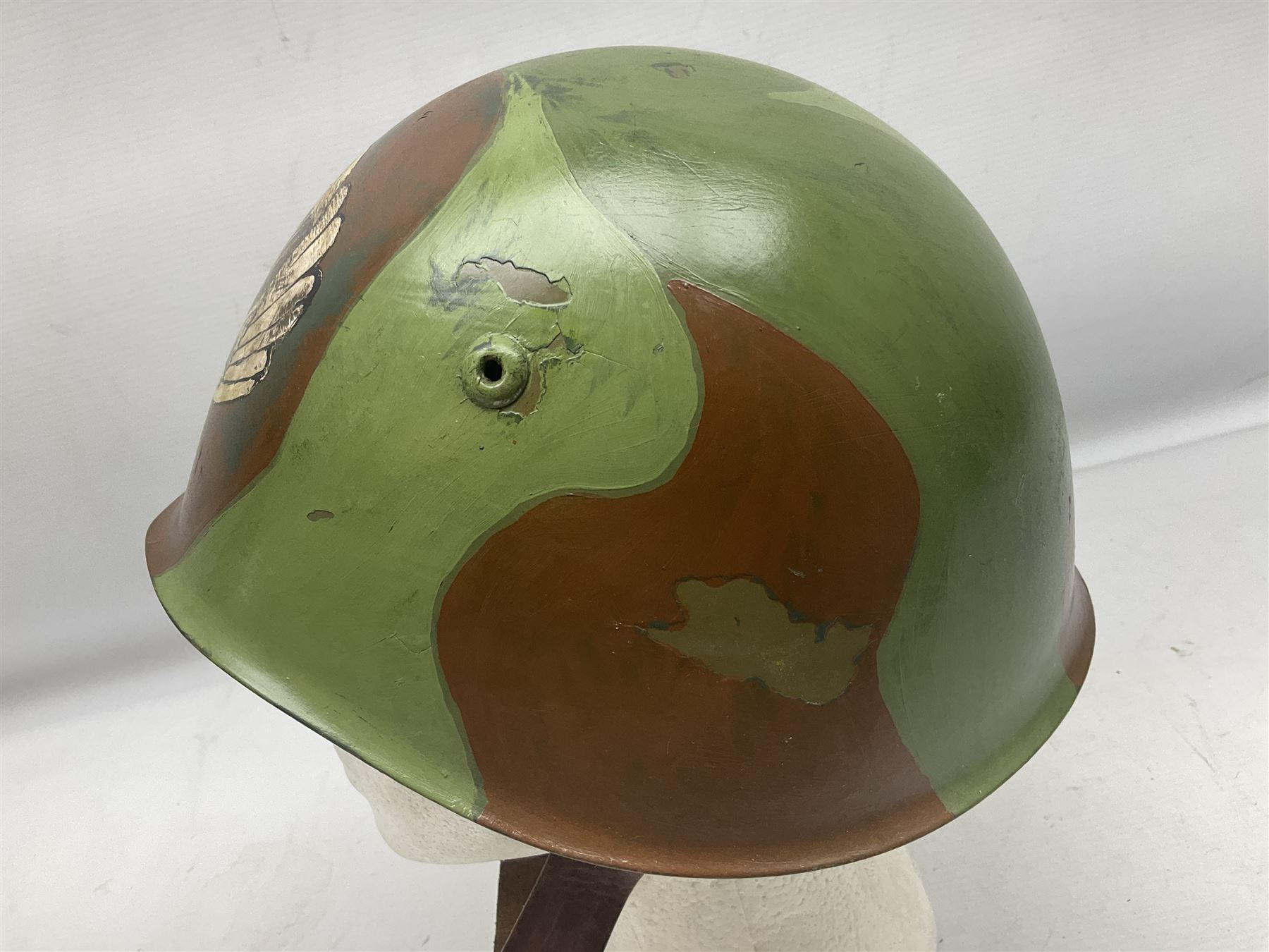 1960s Italian parachutist helmet with liner; camouflage paintwork with parachutist crest to the front