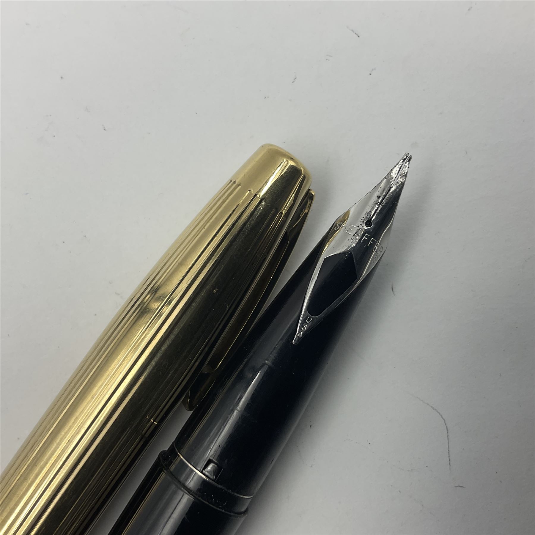 Sheaffer Crest fountain pen, the black barrel with gold plated cap and 18K nib, together with a matching ballpoint pen and further fountain pen, longest L14cm (3)