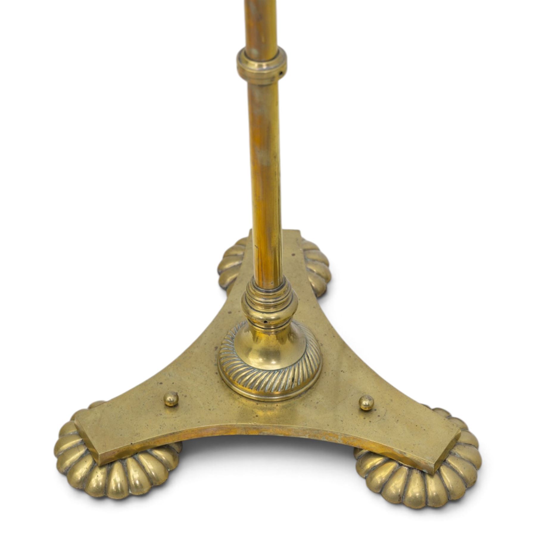 Art Deco brass standard lamp, telescopic column with level action, ring turned collars, raised on a shaped tri-form base with fluted pad feet, complete with green fabric fringed shade