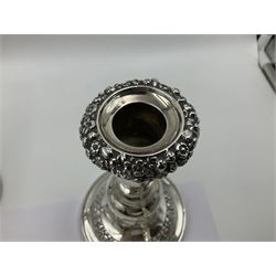 Four George III silver candlesticks, each upon knopped stem and weighted circular stepped foot, the foot and removable sconce repousse decorated with a band of flower heads, hallmarked to sconce and foot Thomas & John Settle, Sheffield 1820, H17.5cm