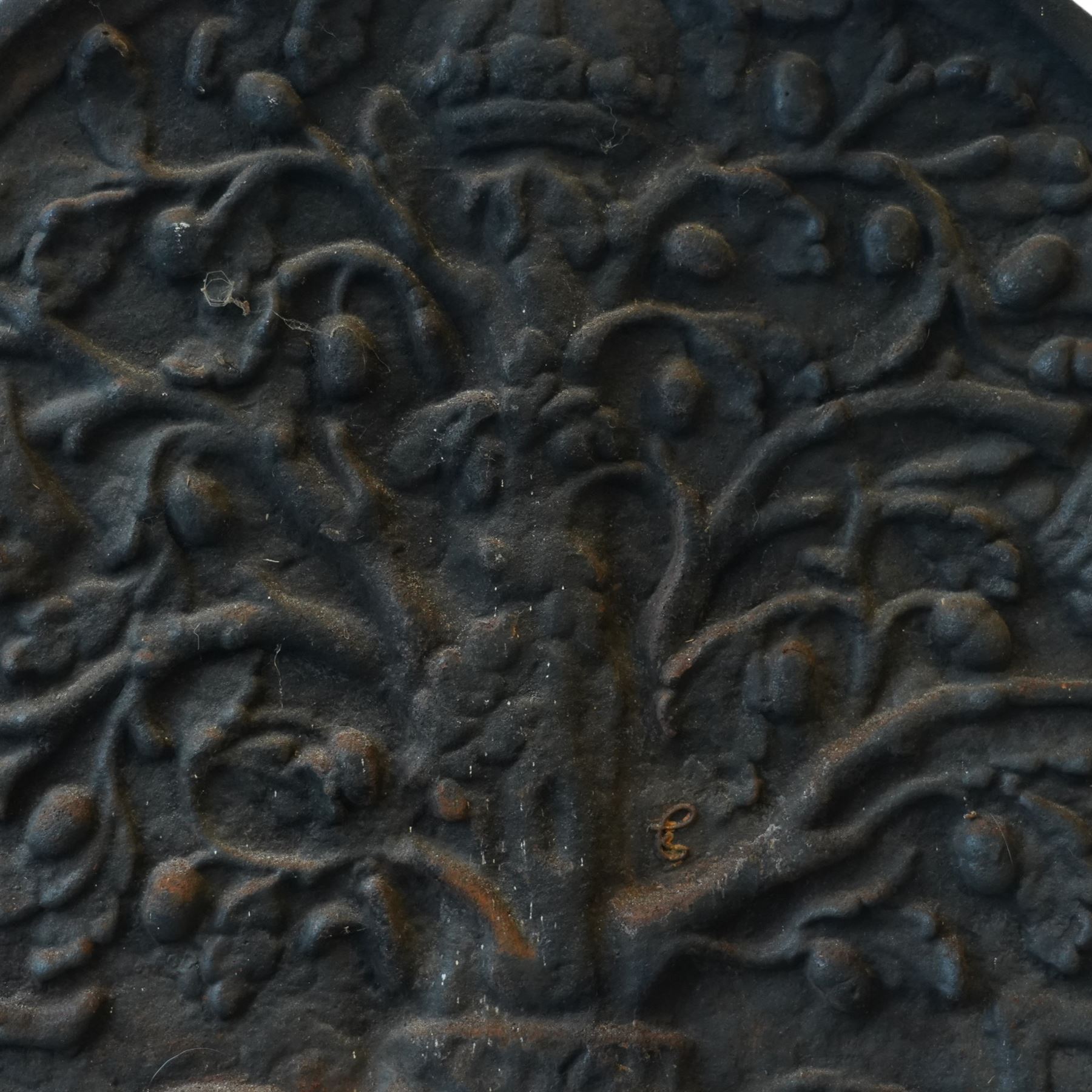 Early 20th century cast iron fireback, arched rectangular form cast in relief with a fruiting oak tree issuing acorns and leaves, surmounted by a crown, the trunk encircled by a ribbon tied cartouche with trailing scrollwork and foliate decoration, within a plain raised border