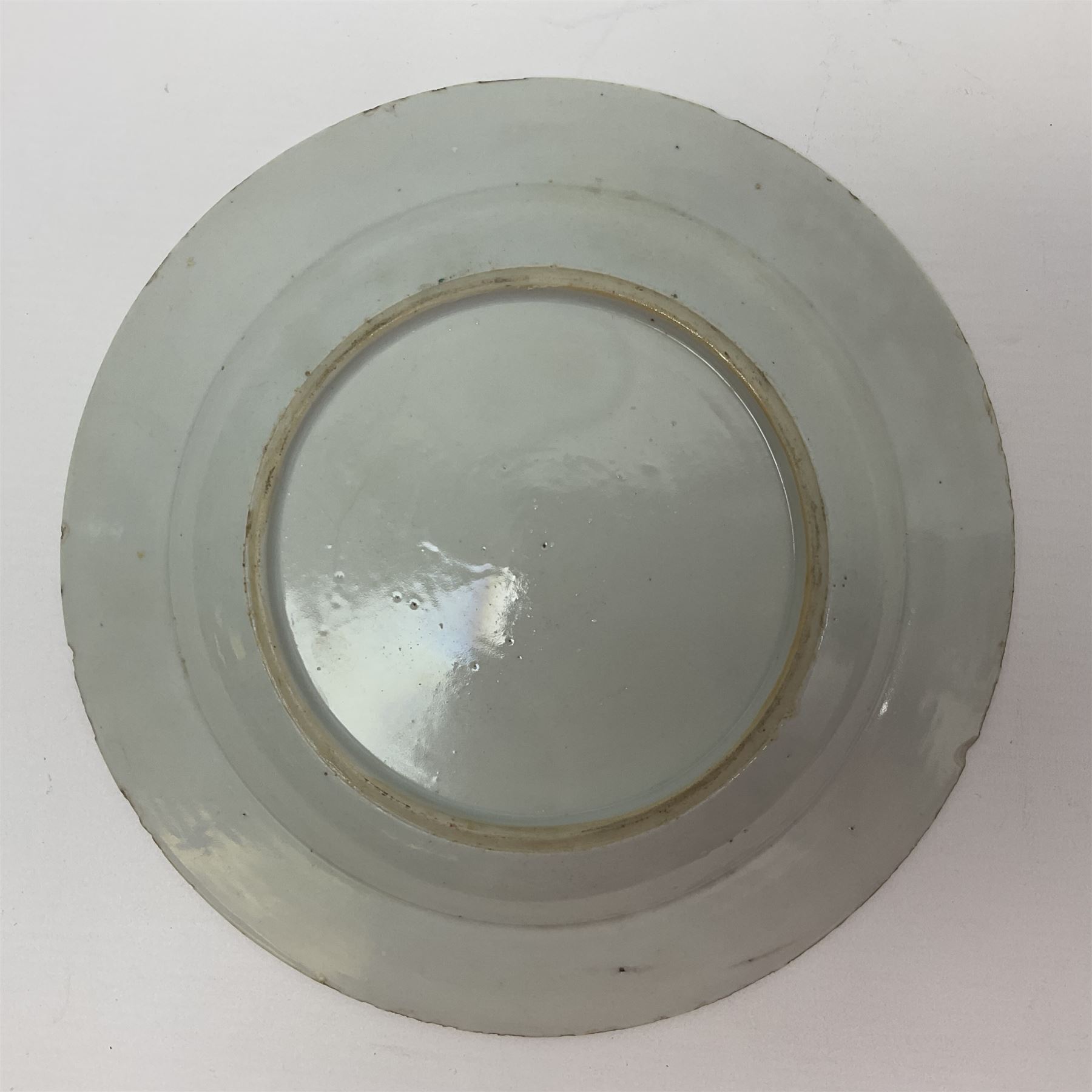 Three 18th century Chinese Famille Rose plates, the first example enamelled with blossoming peonies, rockwork and fence, the other two examples of similar design, decorated with blossoming peonies and sprigs within shaped inner borders, each approximately D23cm