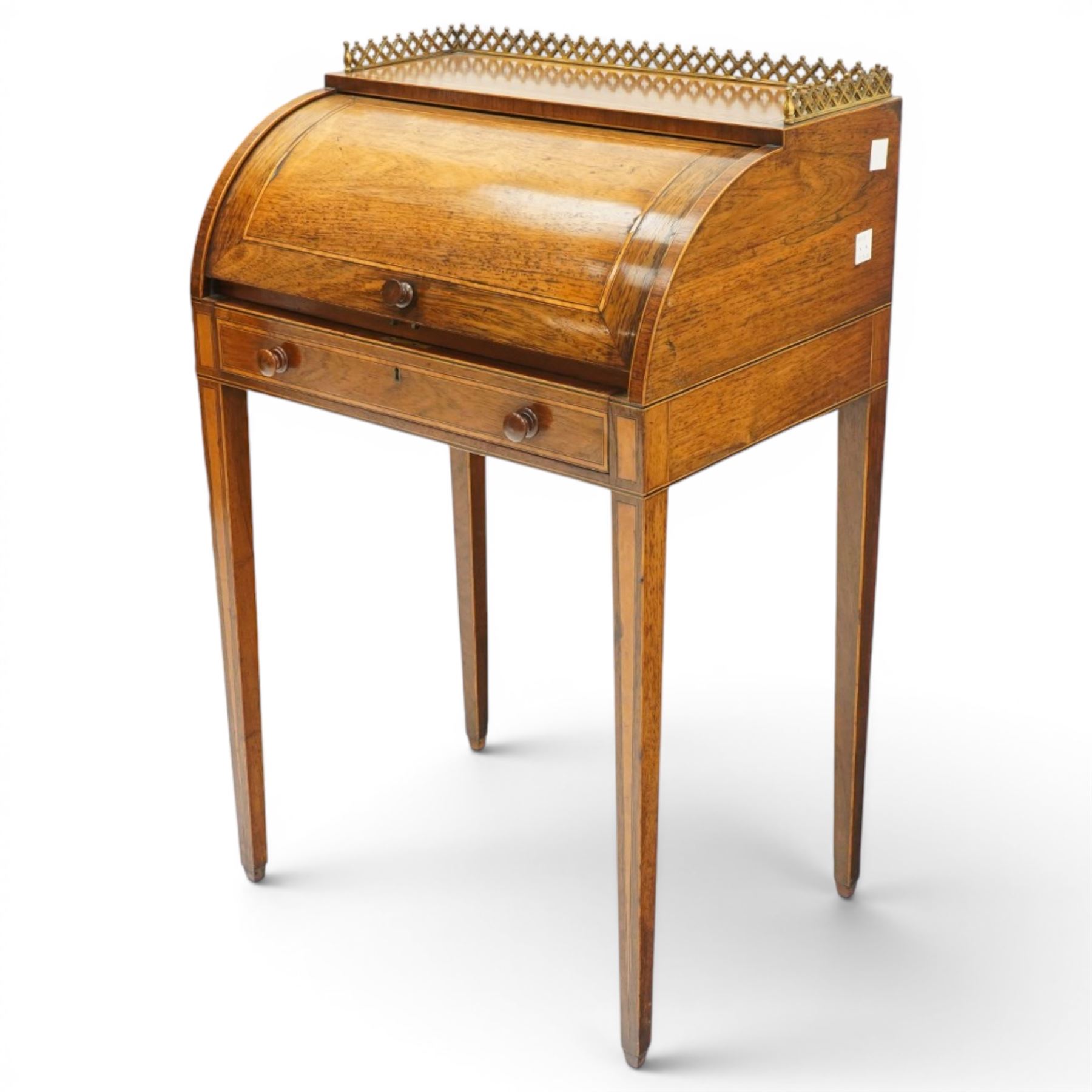 Regency period inlaid mahogany Ladies cylinder writing desk, the rectangular satinwood banded top with raised pierced brass three-quarter gallery, over a cylindrical roll-top enclosing a satinwood fitted interior with pigeonholes, correspondence drawers, ink wells and a sliding hinged writing slope, the base fitted with single frieze drawer, raised on square tapering supports
Provenance: Kirkham Hall