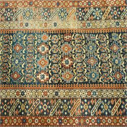 Two antique Caucasian Shirvan rugs, indigo field decorated with horizontal bands of small geometric floral and star motifs within multiple finely drawn borders featuring diamonds, rosettes, and stylized leaves in a palette of madder red, ivory, ochre, and pale blue, with fringe ends, 195x137cm, together with a similar smaller rug, 143x96cm