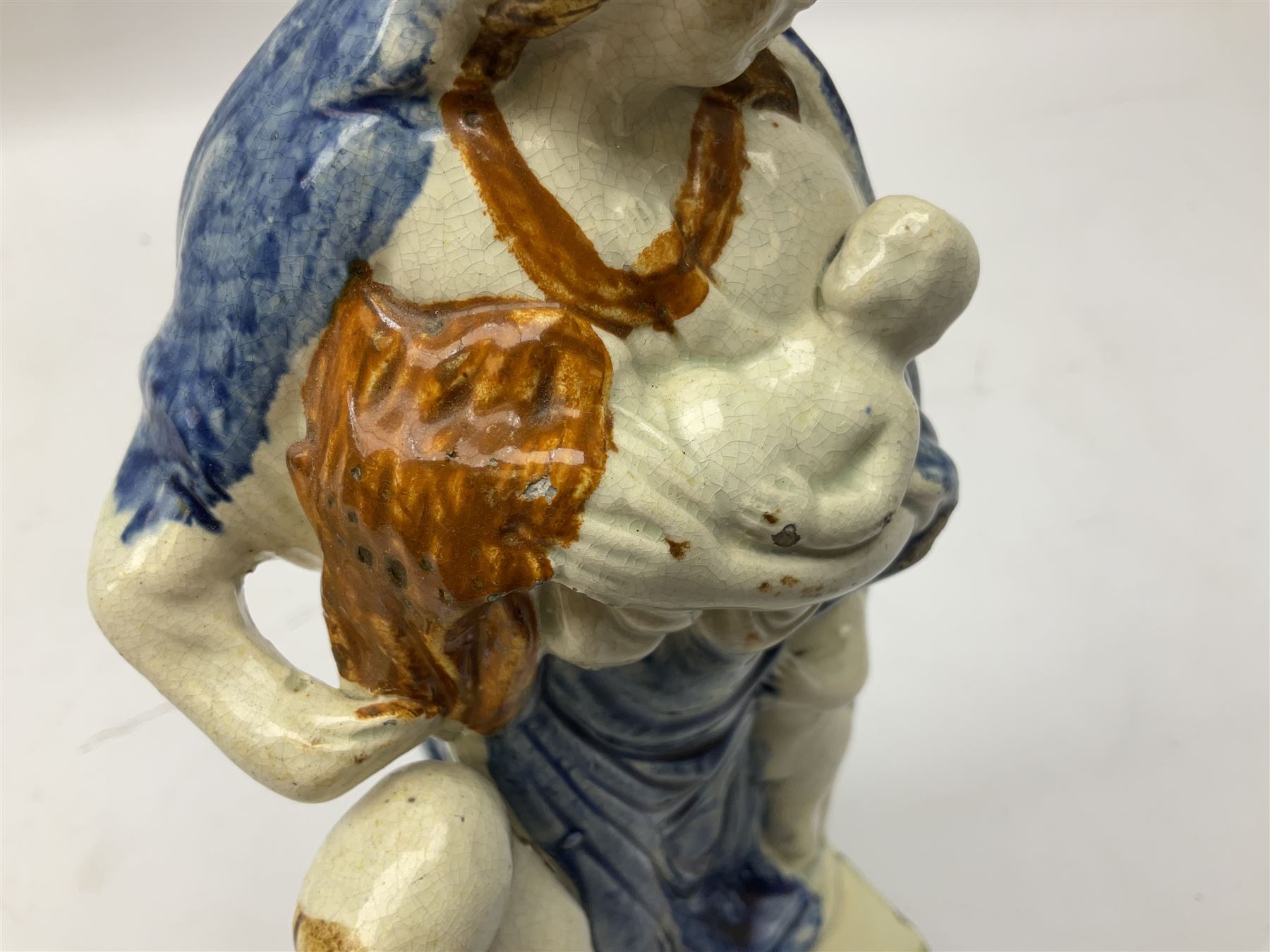 Late 18th century Prattware figure representing Charity, modelled as a mother with baby in her arms and two small children clutching at her robes, upon a square base, overall H21cm.