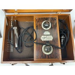 W & J George Ltd Nivoc dip circle in revolving double-glazed case with bevelled panels and adjustable feet H27cm; early 20th century Griffin & George Ltd. Induction Coil Spark Generator on mahogany base; and J. Heal Violet Ray High Frequency Generator; in wooden case with range of glass attachments (3)